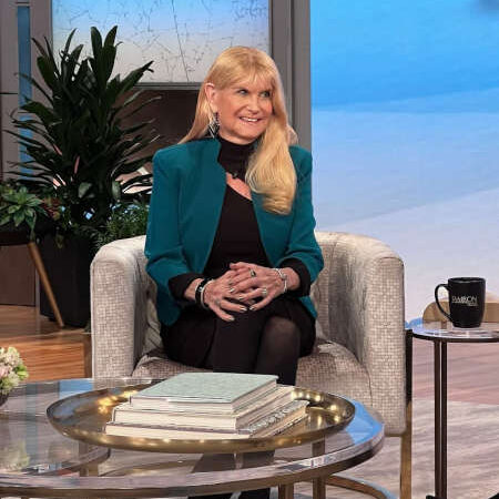 Woman in teal blazer on talk show.